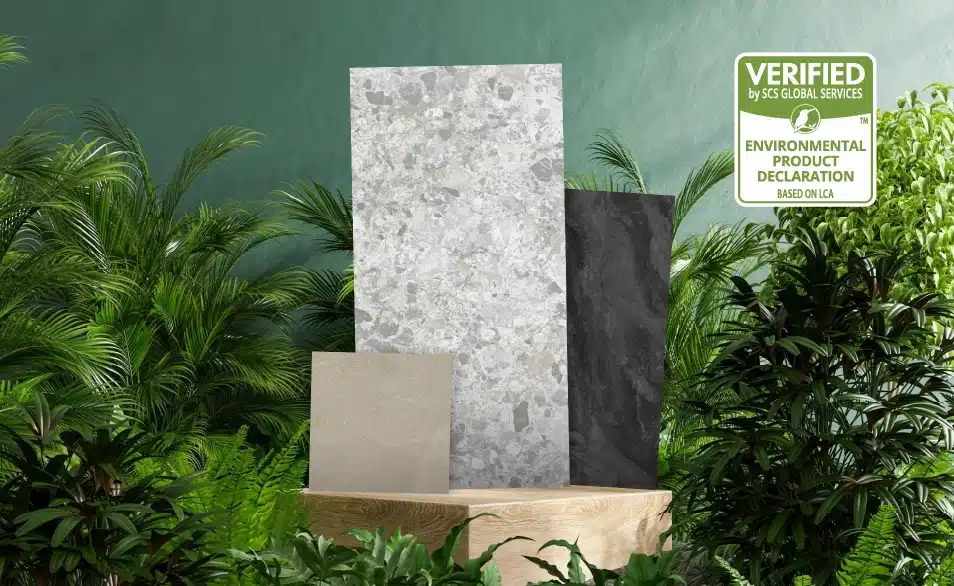 Niro-Granites-Tiles-On-Environmentalism-Quality-Standards A small green-coloured labeling that denotes 'Environmental Product Declaration' and is verified by SCS Global Services is seen, where three different design types and sizes of Niro Granite's tiles are placed on top of a wooden block that is surrounded by a green bush of leaves. This shows that Niro Granite's tiles are eco-friendly in manufacturing.
